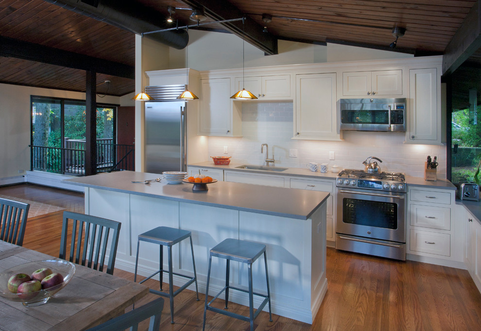 Open concept kitchen - transitional l-shaped open concept kitchen idea with an undermount sink, shaker cabinets, white cabinets, quartz countertops, blue backsplash, ceramic backsplash and stainless steel appliances