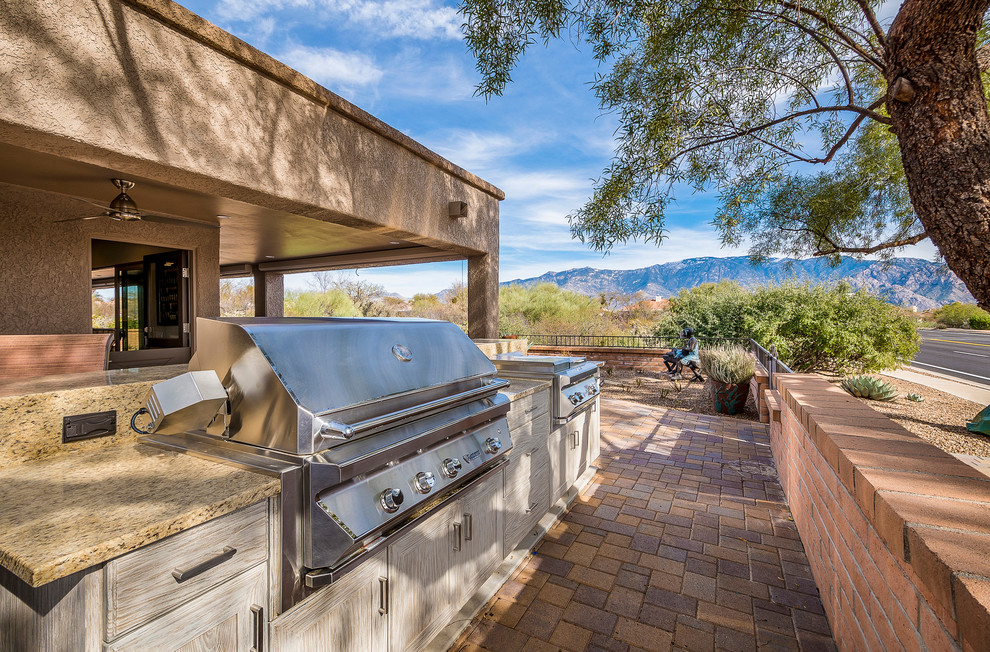 This is an example of a traditional backyard deck in Phoenix with an outdoor kitchen and no cover.