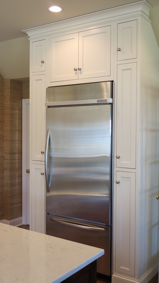 Example of a transitional home design design with white cabinets, quartz countertops and white backsplash