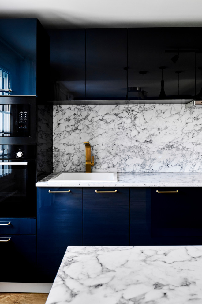 This is an example of a large contemporary single-wall open plan kitchen in Paris with beaded inset cabinets, blue cabinets, light hardwood floors, with island, a single-bowl sink, laminate benchtops and black appliances.