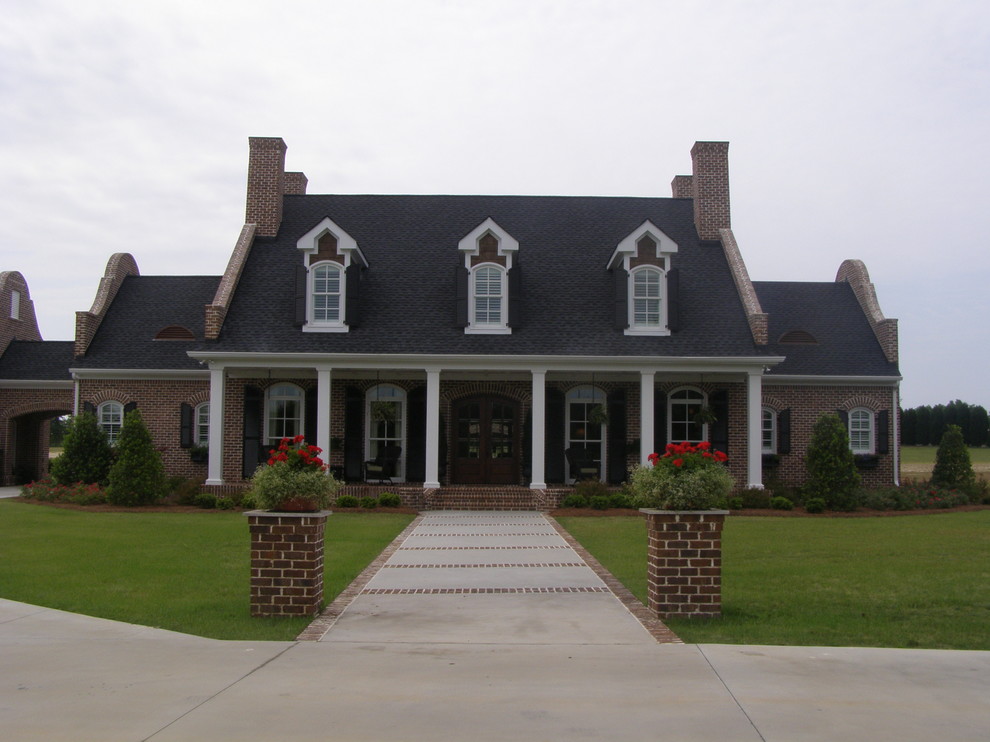 Large traditional two-storey brick red exterior in Atlanta with a gable roof.