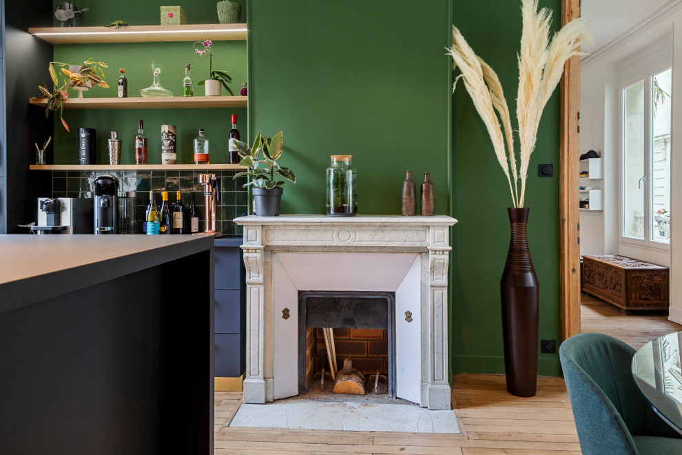 Réalisation d'une salle de séjour tradition de taille moyenne et ouverte avec un mur vert, parquet clair, une cheminée standard et un manteau de cheminée en pierre.