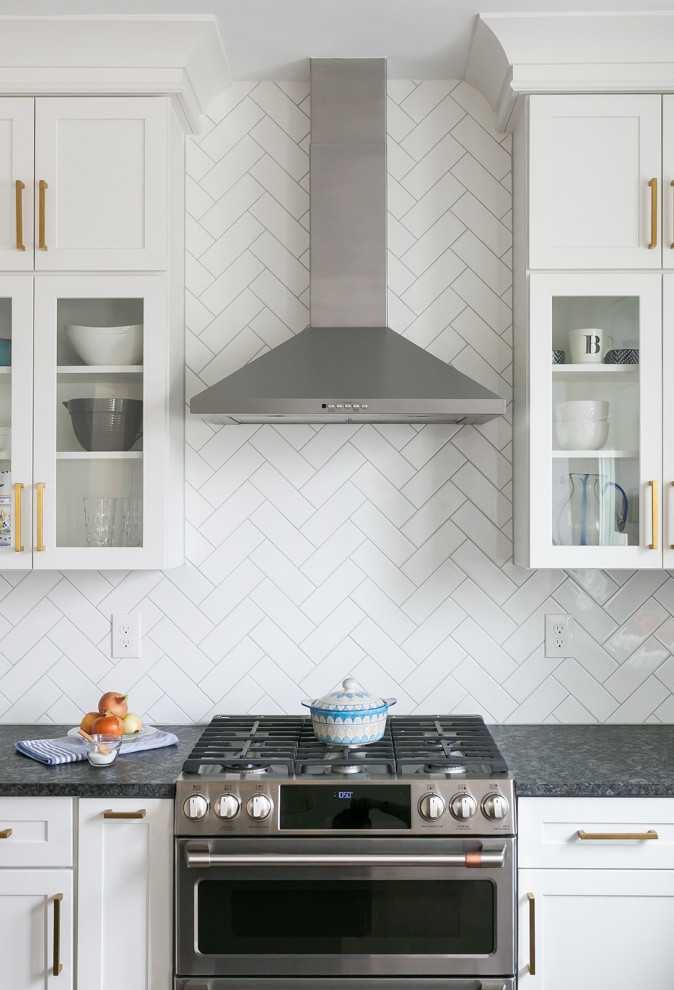 Example of a large transitional l-shaped brown floor kitchen pantry design in Baltimore with a drop-in sink, shaker cabinets, white cabinets, quartz countertops, white backsplash, ceramic backsplash, stainless steel appliances, an island and white countertops