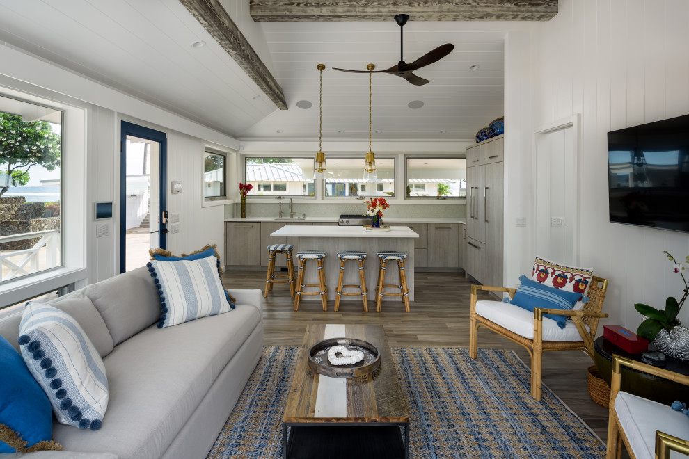 Inspiration for a small beach style open concept living room in Hawaii with white walls, porcelain floors, a wall-mounted tv, grey floor, exposed beam and panelled walls.