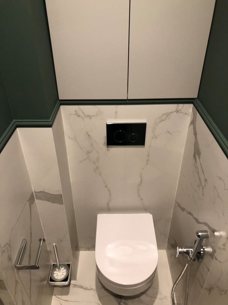 Mid-sized transitional powder room in Saint Petersburg with flat-panel cabinets, grey cabinets, a wall-mount toilet, white tile, porcelain tile, green walls, porcelain floors, a drop-in sink, wood benchtops, white floor and a built-in vanity.