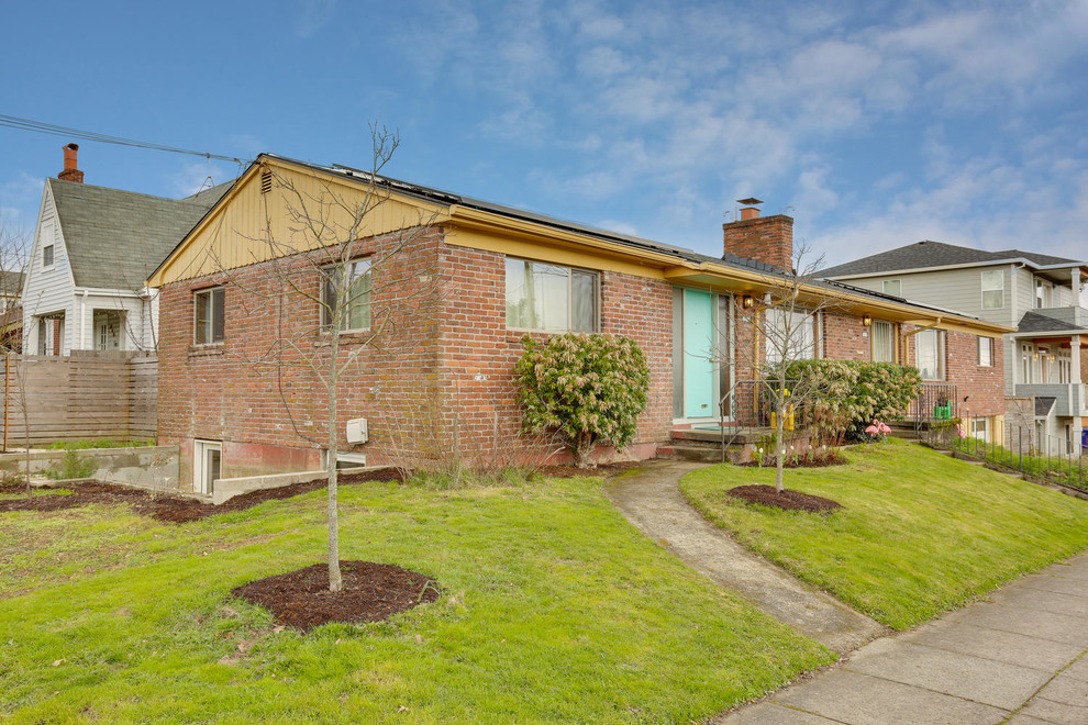 Photo of a mid-sized midcentury one-storey brick red duplex exterior in Portland with a gable roof and a shingle roof.