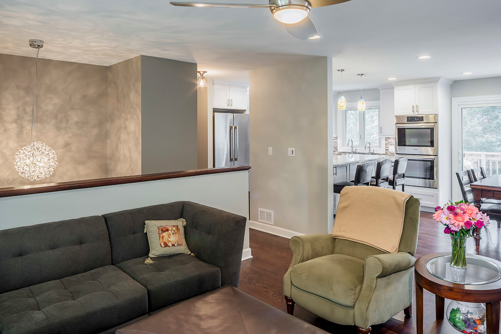 Home design - mid-sized transitional u-shaped medium tone wood floor home design idea in Chicago with a farmhouse sink, recessed-panel cabinets, white cabinets, granite countertops, gray backsplash, glass tile backsplash, stainless steel appliances and an island