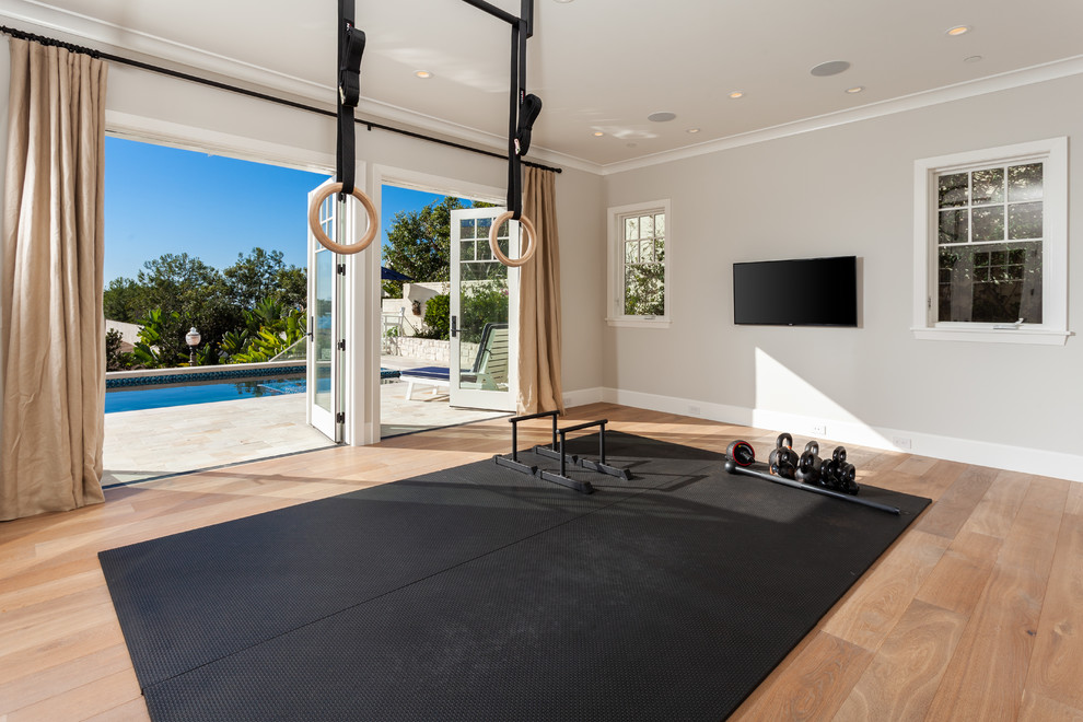 Inspiration for a beach style home gym in Orange County with grey walls and light hardwood floors.