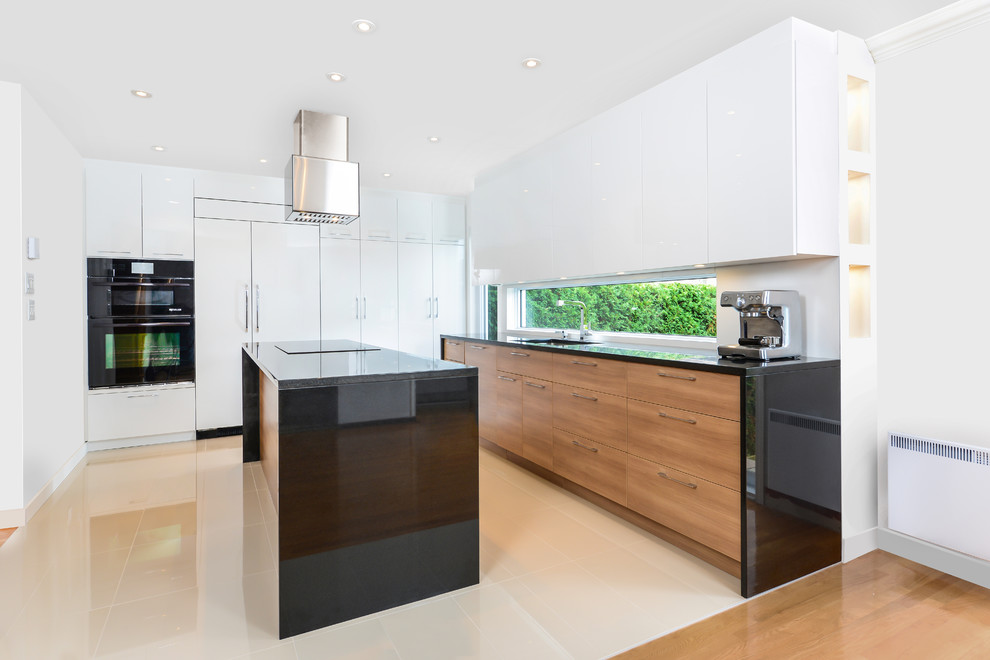 Inspiration for a contemporary eat-in kitchen in Montreal with window splashback, black appliances, with island, beige floor, an undermount sink, flat-panel cabinets, granite benchtops and porcelain floors.