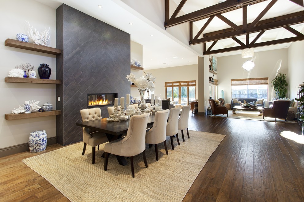This is an example of a large mediterranean open plan dining in San Francisco with white walls, dark hardwood floors, a ribbon fireplace and a tile fireplace surround.