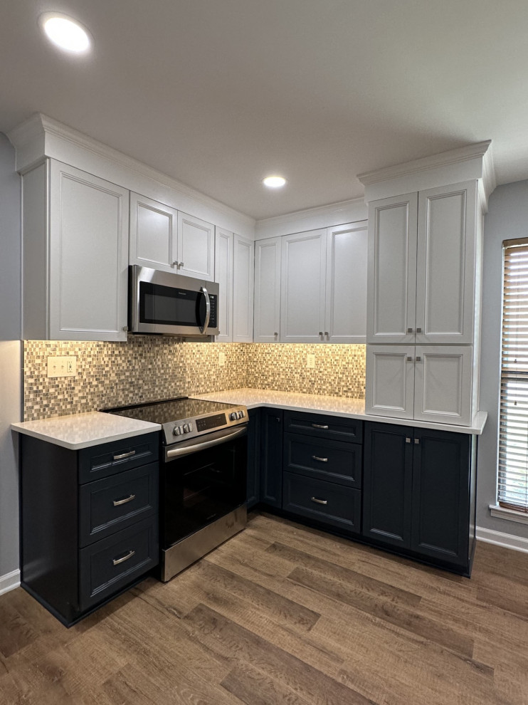 Small classic l-shaped enclosed kitchen in Other with a belfast sink, shaker cabinets, blue cabinets, engineered stone countertops, stainless steel appliances, laminate floors, beige floors and white worktops.