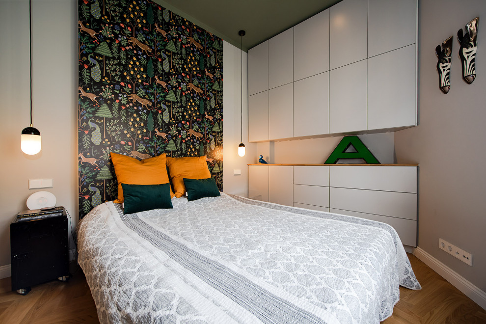 На фото: хозяйская спальня среднего размера в стиле фьюжн с зелеными стенами, светлым паркетным полом, коричневым полом и обоями на стенах с