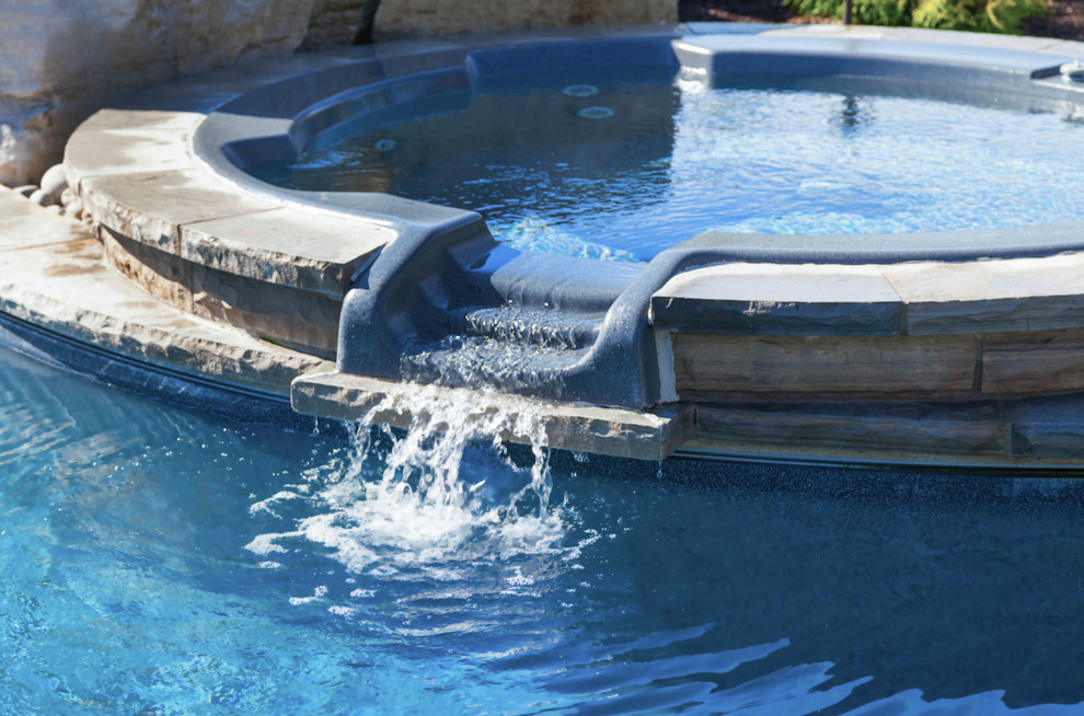 Example of a small transitional concrete paver and rectangular infinity pool design in Toronto