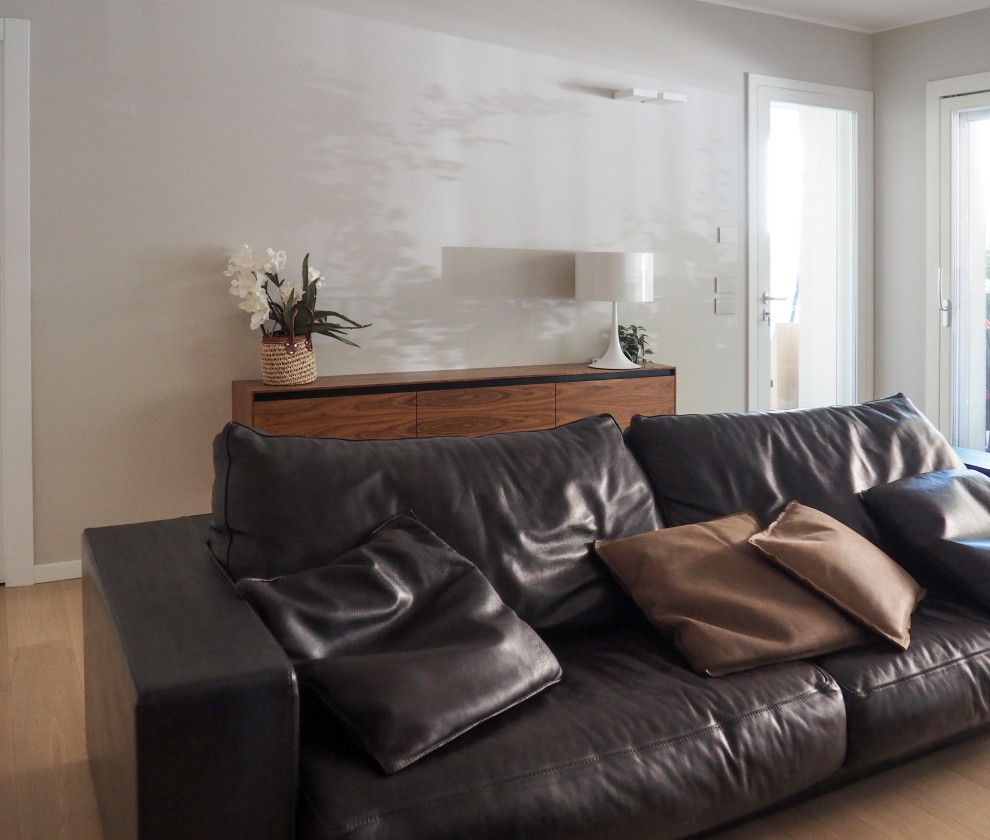 Idee per un soggiorno contemporaneo di medie dimensioni e aperto con pareti grigie e parquet chiaro
