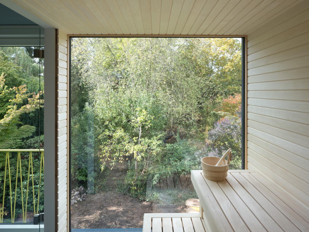 Modelo de sauna minimalista de tamaño medio con paredes beige, suelo de azulejos de cemento, suelo azul, madera y madera