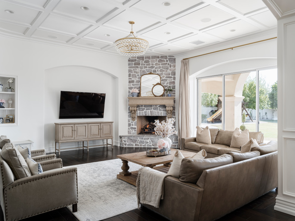 Inspiration for a large formal open concept living room in Phoenix with white walls, dark hardwood floors, a standard fireplace, a stone fireplace surround, a wall-mounted tv and brown floor.