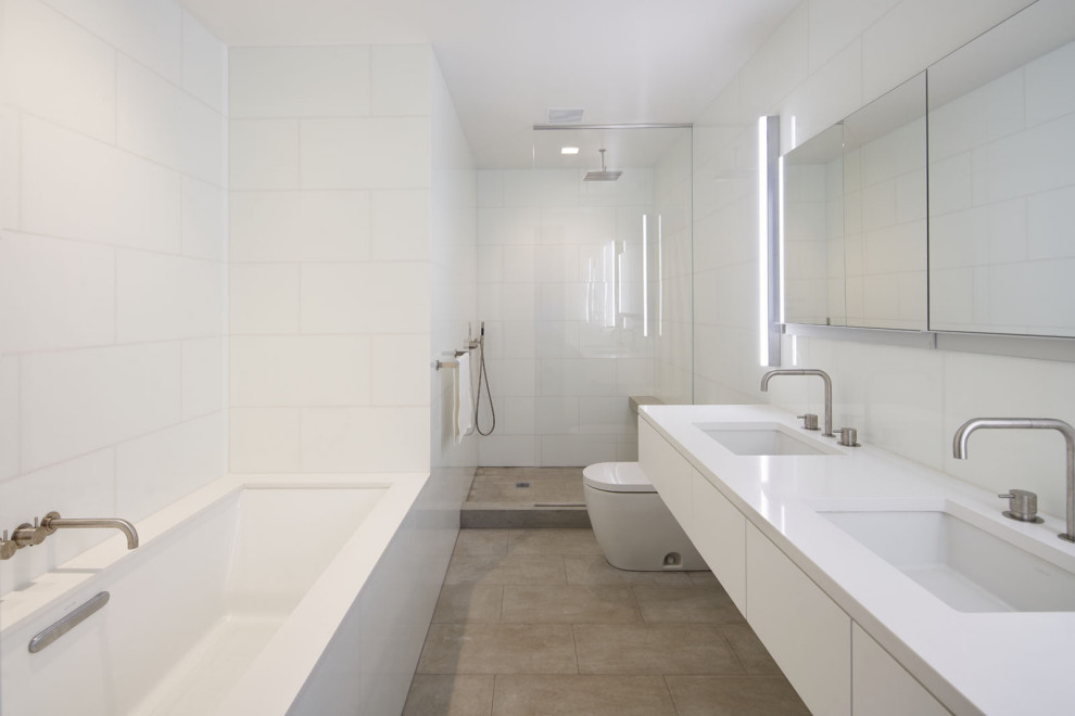 Стильный дизайн: большая главная ванная комната в стиле модернизм с плоскими фасадами, белыми фасадами, накладной ванной, открытым душем, унитазом-моноблоком, белой плиткой, стеклянной плиткой, белыми стенами, полом из известняка, врезной раковиной, столешницей из кварцита, бежевым полом, открытым душем, белой столешницей, сиденьем для душа, тумбой под две раковины, подвесной тумбой и многоуровневым потолком - последний тренд
