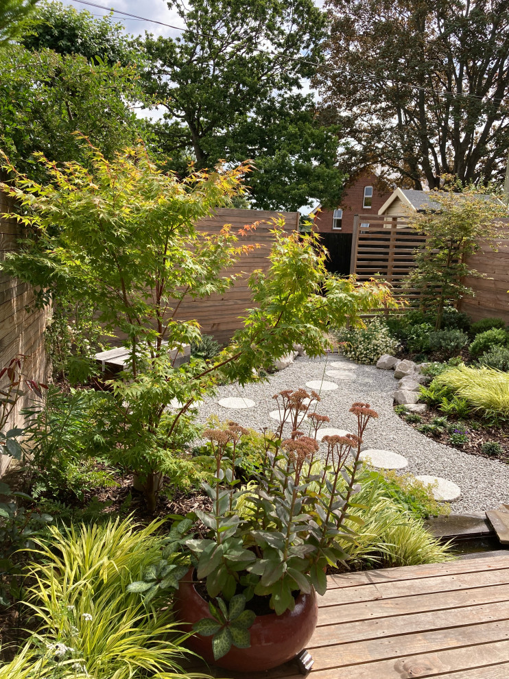 На фото: маленький участок и сад на заднем дворе в восточном стиле с полуденной тенью, покрытием из гравия и с деревянным забором для на участке и в саду с