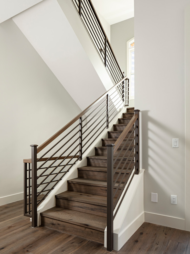 Example of a large transitional open concept light wood floor and brown floor staircase design in Phoenix with white walls, a ribbon fireplace, a stone fireplace and a wall-mounted tv