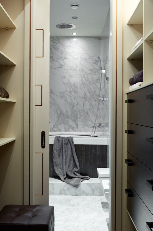 Small contemporary gender-neutral walk-in wardrobe in Moscow with flat-panel cabinets and dark wood cabinets.