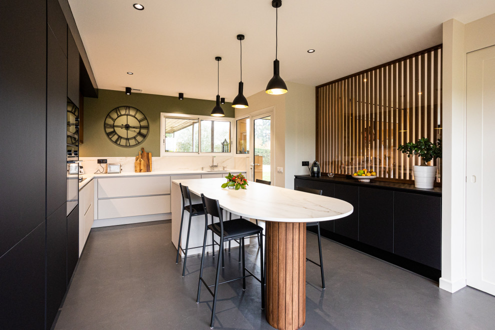 Photo of a large contemporary l-shaped separate kitchen in Bordeaux with an undermount sink, beaded inset cabinets, black cabinets, marble benchtops, beige splashback, marble splashback, stainless steel appliances, concrete floors, with island, grey floor and beige benchtop.