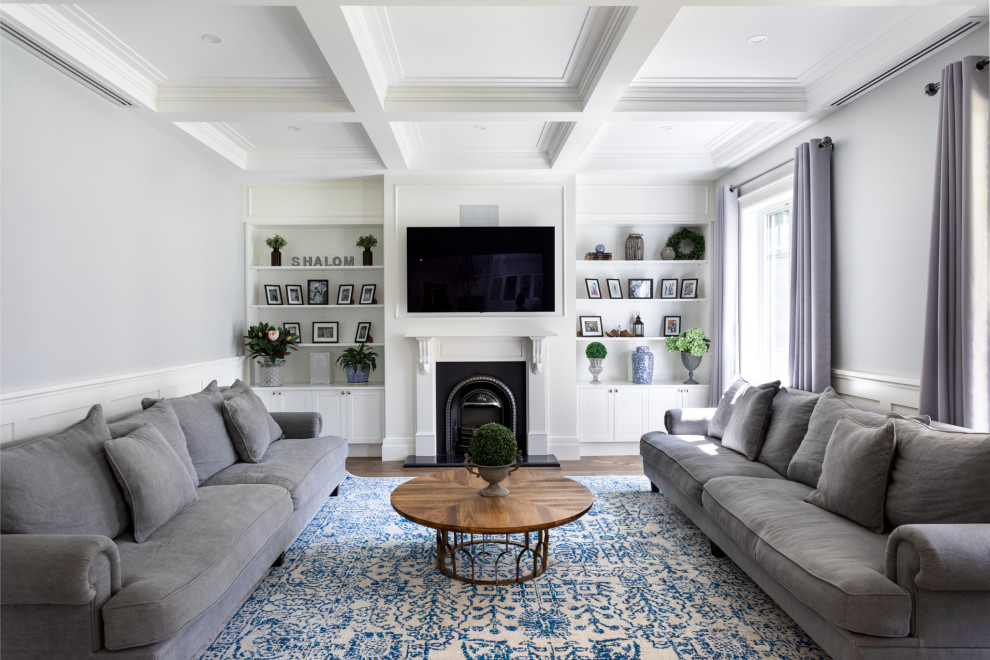 This is an example of a transitional living room in Melbourne with white walls, dark hardwood floors, a standard fireplace, a wall-mounted tv, brown floor, coffered and decorative wall panelling.