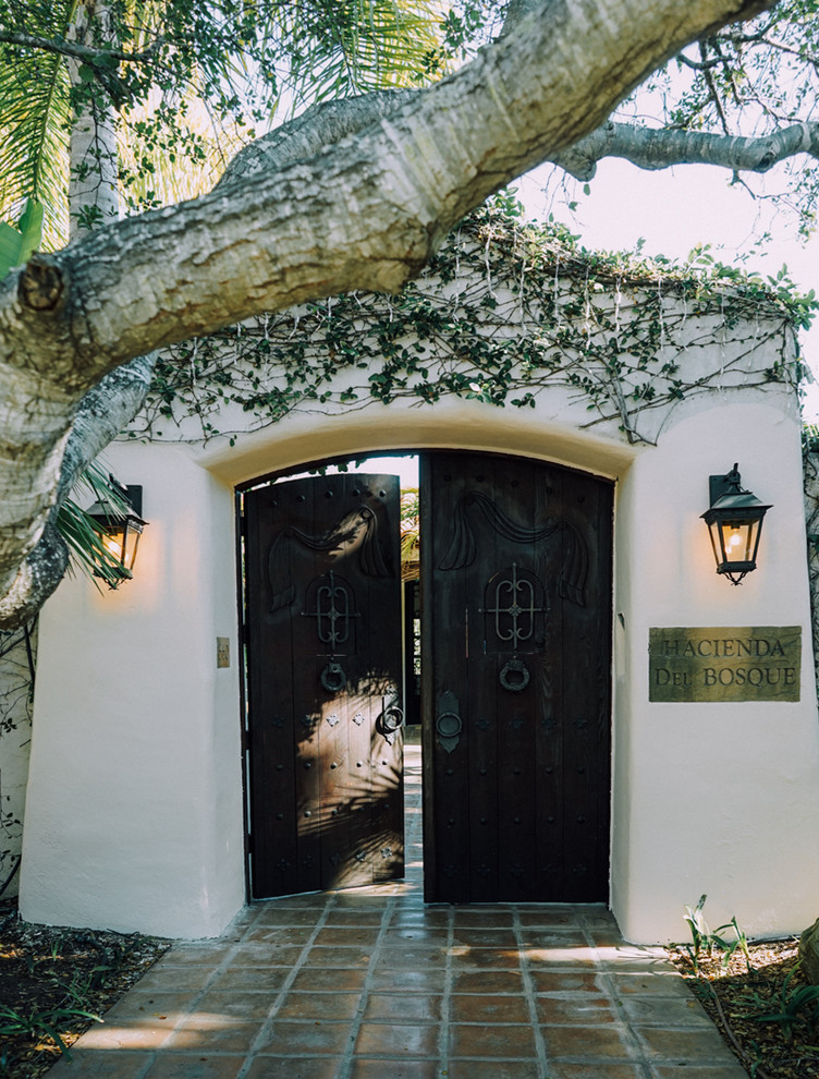 Photo of a large mediterranean adobe white exterior in Santa Barbara with a gable roof.