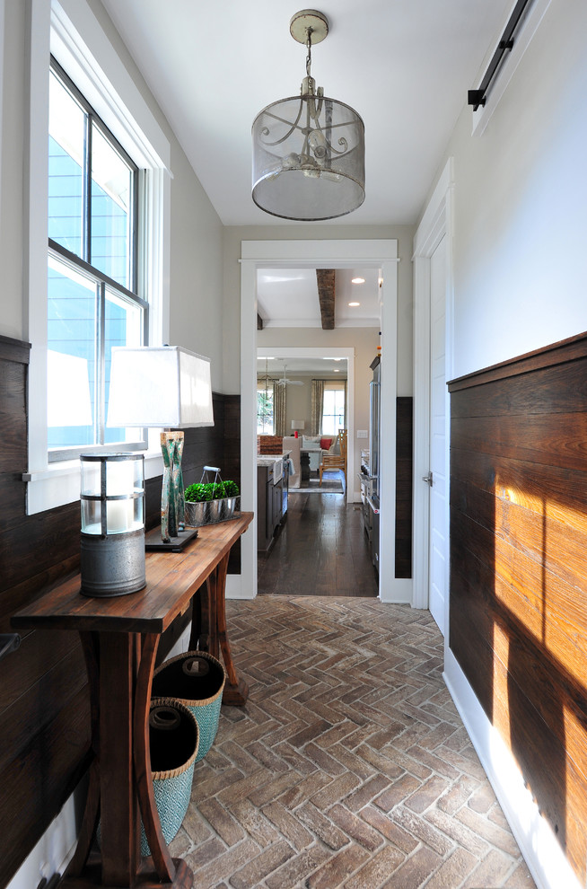 Design ideas for a transitional hallway in Atlanta with beige walls, brick floors and brown floor.