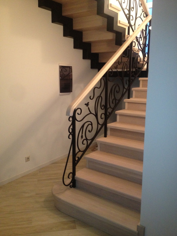 Foto de escalera en U tradicional de tamaño medio con escalones de madera, contrahuellas de madera, barandilla de metal y papel pintado