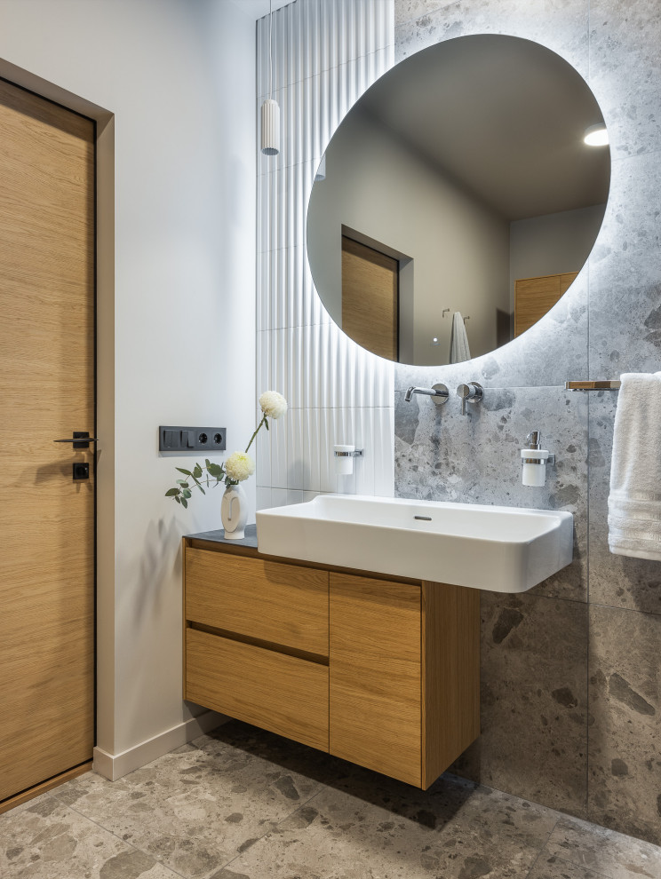 Contemporary bathroom in Other with flat-panel cabinets, medium wood cabinets, grey tiles, white walls, grey floors, a single sink, a floating vanity unit and a wall-mounted sink.