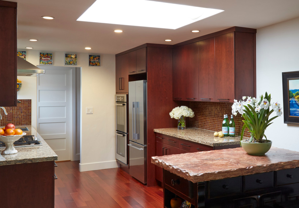 Small midcentury galley eat-in kitchen in San Francisco with an undermount sink, flat-panel cabinets, dark wood cabinets, granite benchtops, brown splashback, mosaic tile splashback, stainless steel appliances, medium hardwood floors and with island.