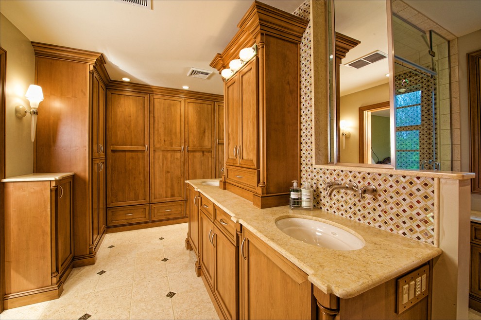 Design ideas for an expansive traditional master bathroom in Philadelphia with recessed-panel cabinets, medium wood cabinets, an alcove shower, a one-piece toilet, multi-coloured tile, mosaic tile, white walls, cement tiles, an undermount sink, granite benchtops, beige floor and a hinged shower door.