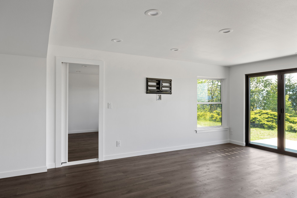 Inspiration for a large transitional single-wall vinyl floor, brown floor and vaulted ceiling open concept kitchen remodel in Seattle with an undermount sink, shaker cabinets, white cabinets, quartz countertops, white backsplash, quartz backsplash, stainless steel appliances, an island and white countertops
