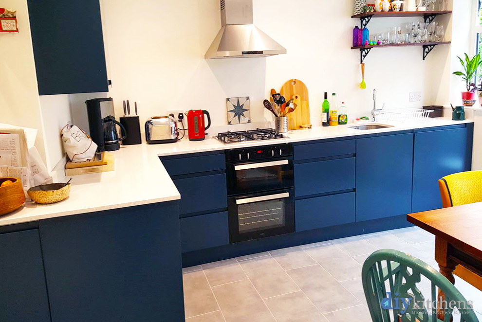 Inspiration for a medium sized modern l-shaped kitchen/diner in West Midlands with flat-panel cabinets, blue cabinets, quartz worktops, no island and white worktops.