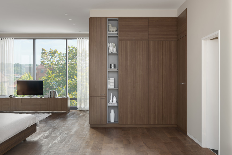 This is an example of a mid-sized modern gender-neutral built-in wardrobe in Nashville with flat-panel cabinets, medium wood cabinets and medium hardwood floors.