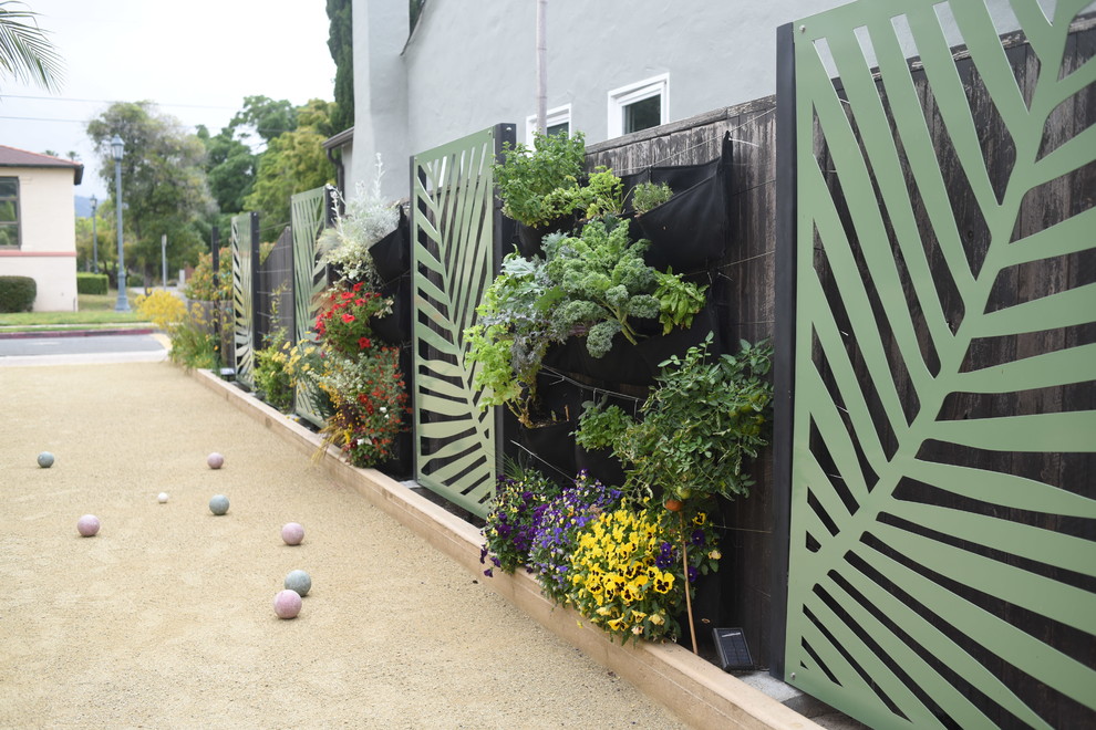 Photo of a small beach style front yard full sun driveway in Santa Barbara with a vertical garden and gravel.
