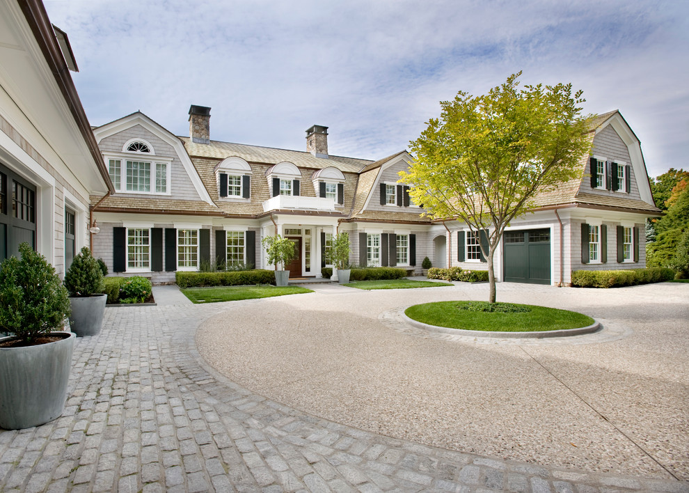 Photo of a large traditional courtyard driveway in Boston with natural stone pavers.