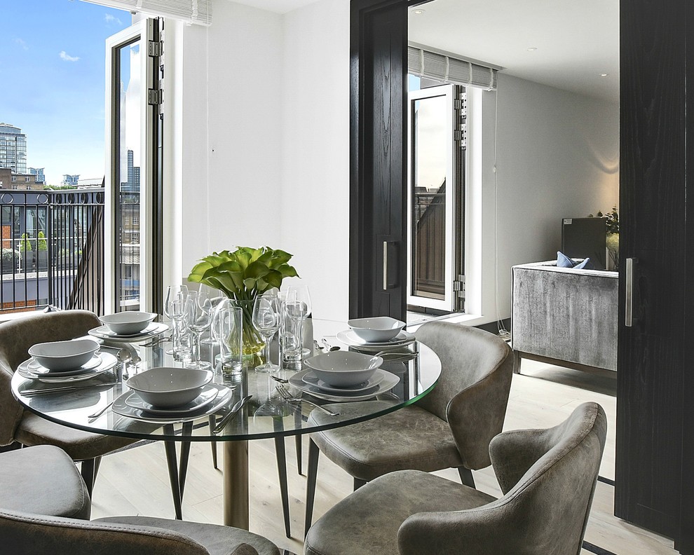 Photo of a small contemporary open plan dining in London with white walls, light hardwood floors and no fireplace.
