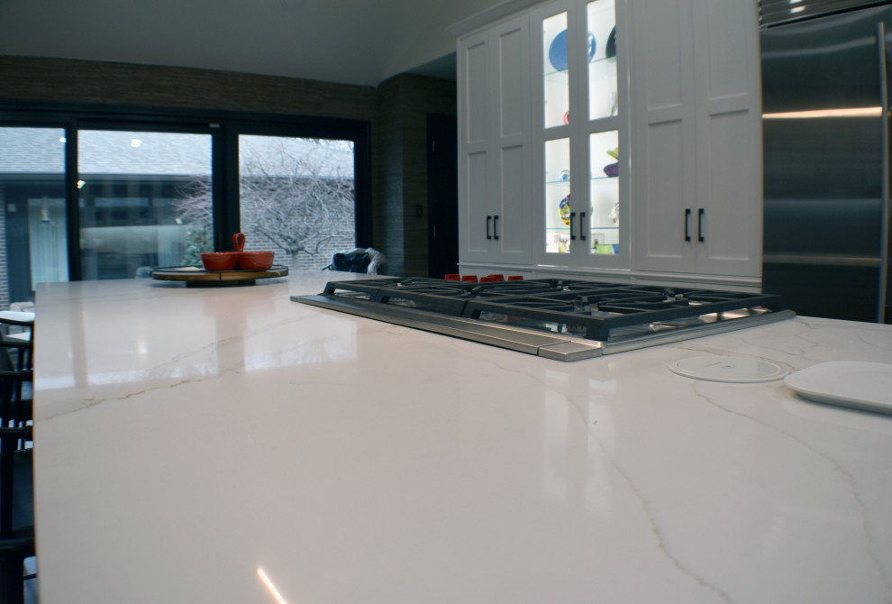 Esempio di una grande cucina minimalista chiusa con lavello a doppia vasca, ante in legno bruno, top in marmo, paraspruzzi bianco, paraspruzzi in marmo, elettrodomestici in acciaio inossidabile, pavimento in vinile, pavimento marrone, top bianco e soffitto a volta