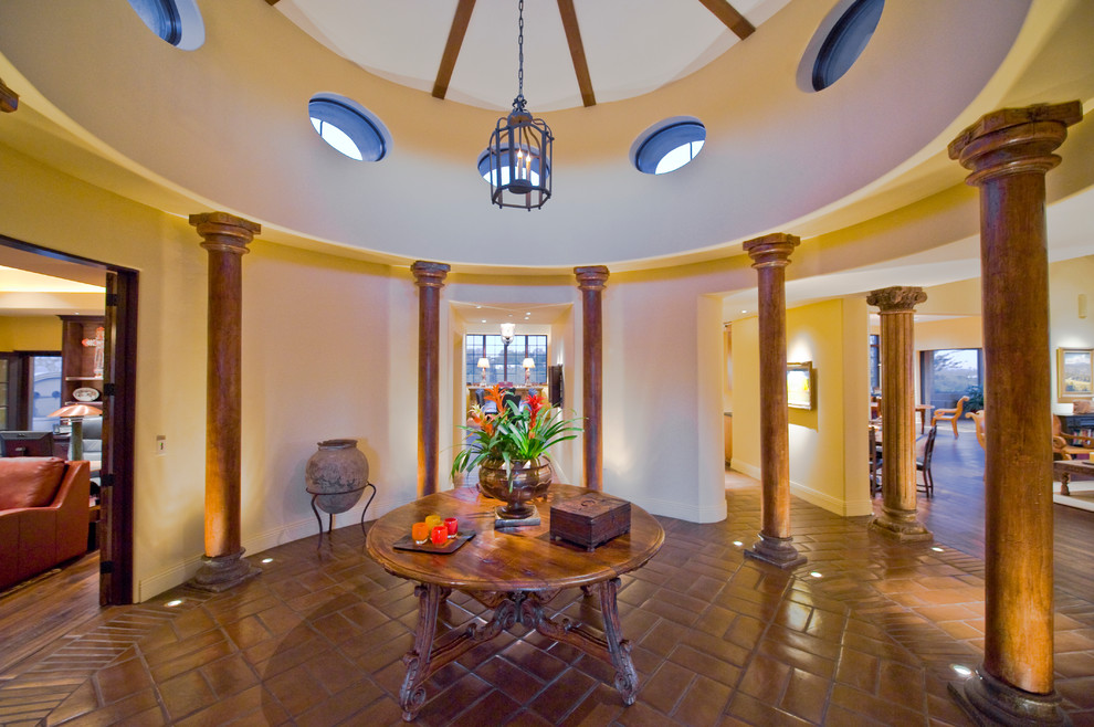 Design ideas for an expansive traditional foyer in Phoenix with yellow walls and terra-cotta floors.