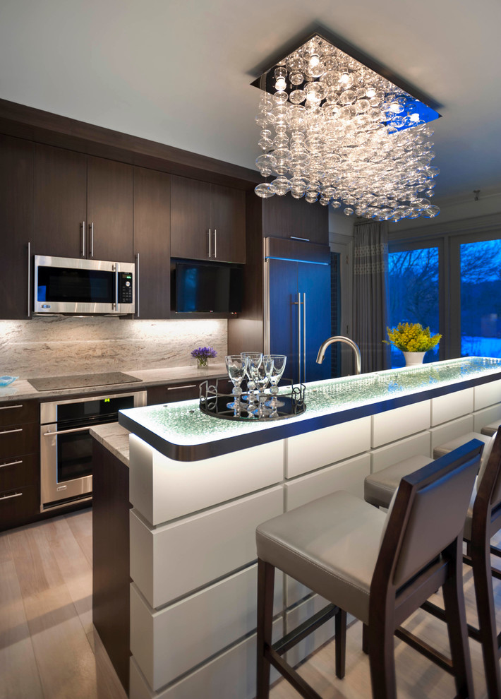 Inspiration for a large contemporary galley kitchen in Detroit with flat-panel cabinets, stainless steel appliances, glass benchtops, a single-bowl sink, dark wood cabinets, brown splashback, stone slab splashback, porcelain floors and with island.