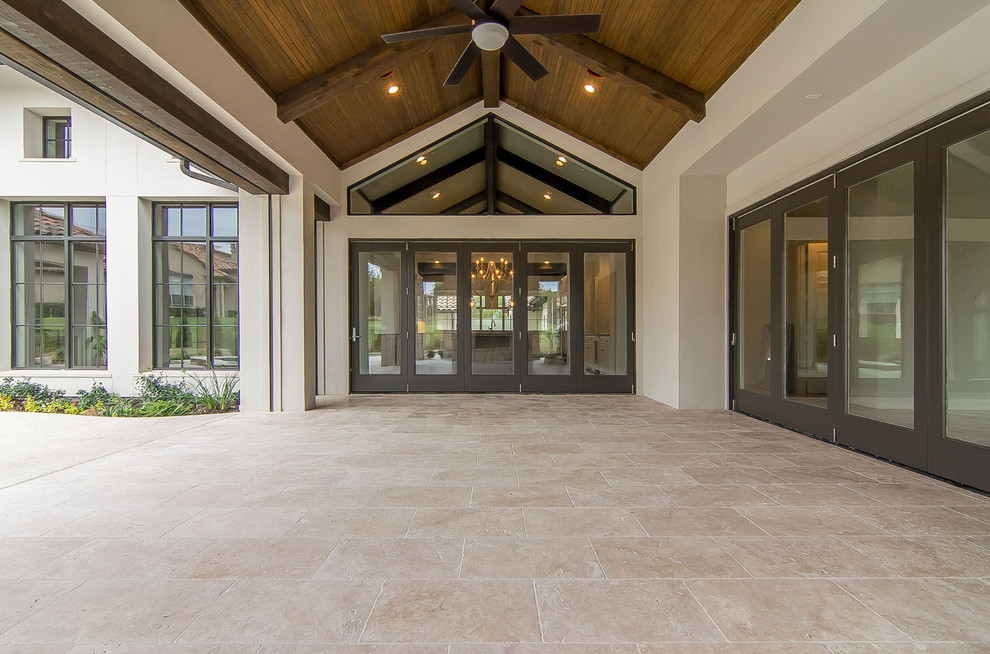 Large mediterranean backyard screened-in verandah in Dallas with natural stone pavers and a roof extension.