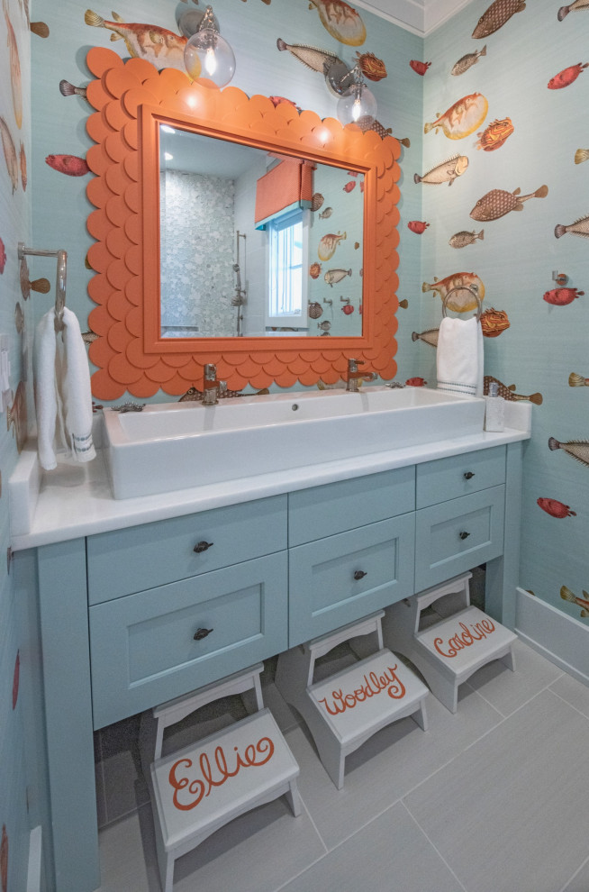 Пример оригинального дизайна: ванная комната в морском стиле с фасадами с утопленной филенкой, синими фасадами, разноцветными стенами, душевой кабиной, настольной раковиной, столешницей из искусственного кварца, серым полом, белой столешницей, тумбой под две раковины, встроенной тумбой и обоями на стенах