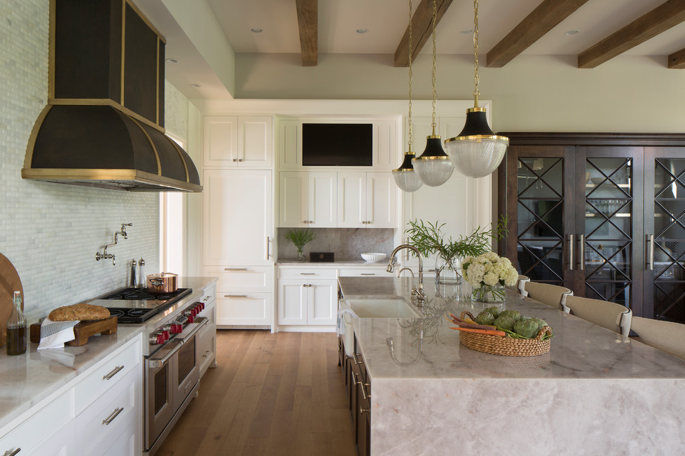 Inspiration for an expansive transitional l-shaped open plan kitchen in Minneapolis with a farmhouse sink, recessed-panel cabinets, marble splashback, stainless steel appliances, medium hardwood floors, with island and brown floor.