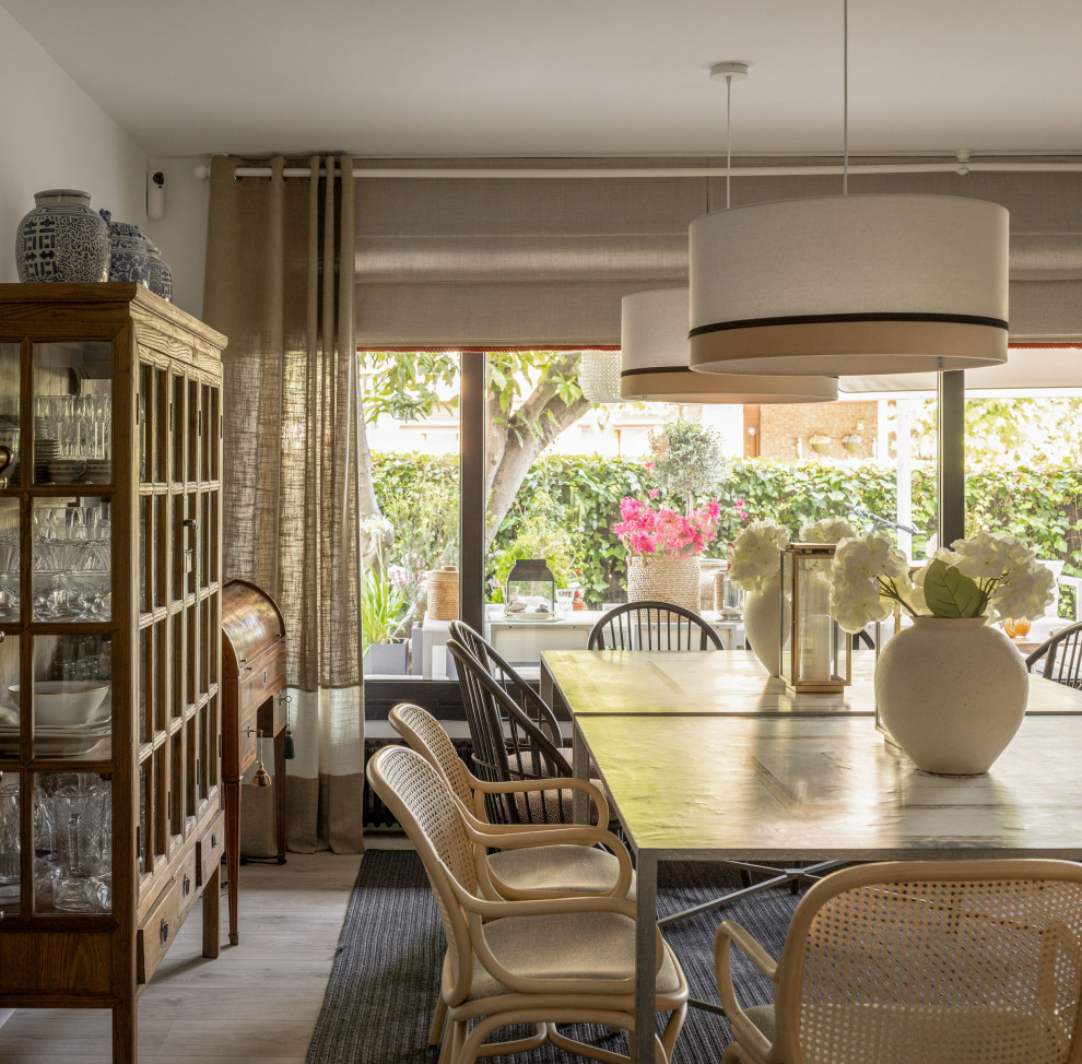 Imagen de comedor clásico renovado grande abierto con paredes grises, suelo laminado, todas las chimeneas, marco de chimenea de piedra, papel pintado y alfombra