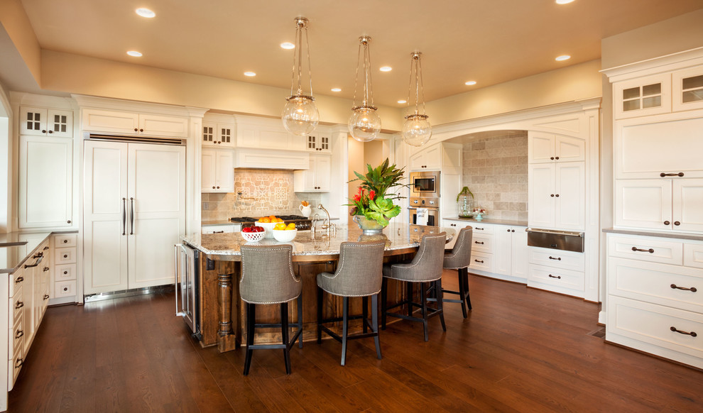 Example of a huge transitional l-shaped dark wood floor eat-in kitchen design in Portland with a farmhouse sink, shaker cabinets, white cabinets, quartz countertops, beige backsplash, mosaic tile backsplash, white appliances and an island
