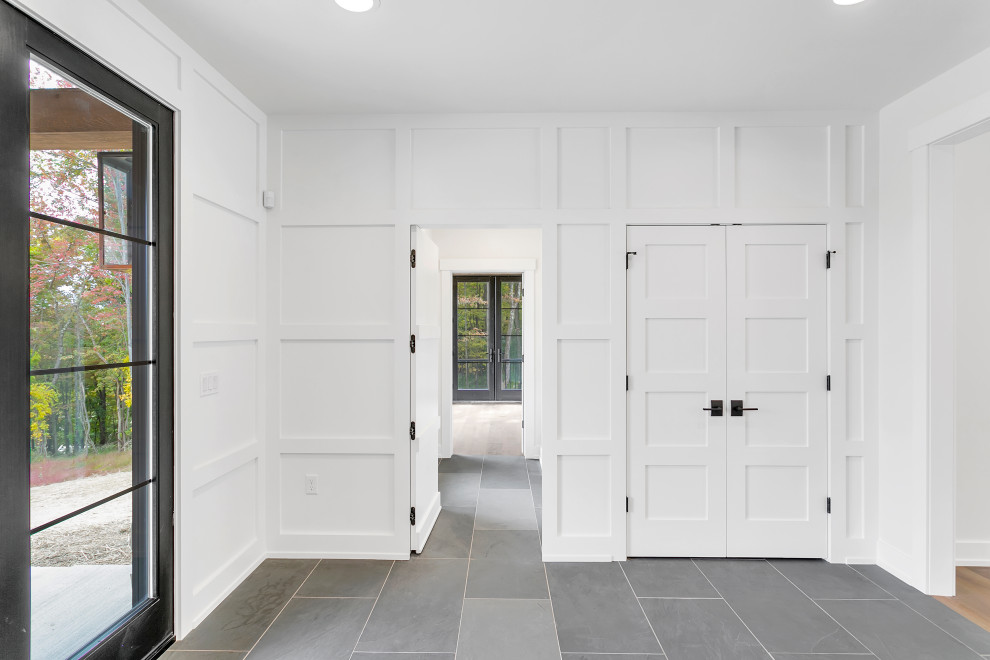 Foyer - large rustic slate floor, gray floor and wall paneling foyer idea with white walls and a black front door
