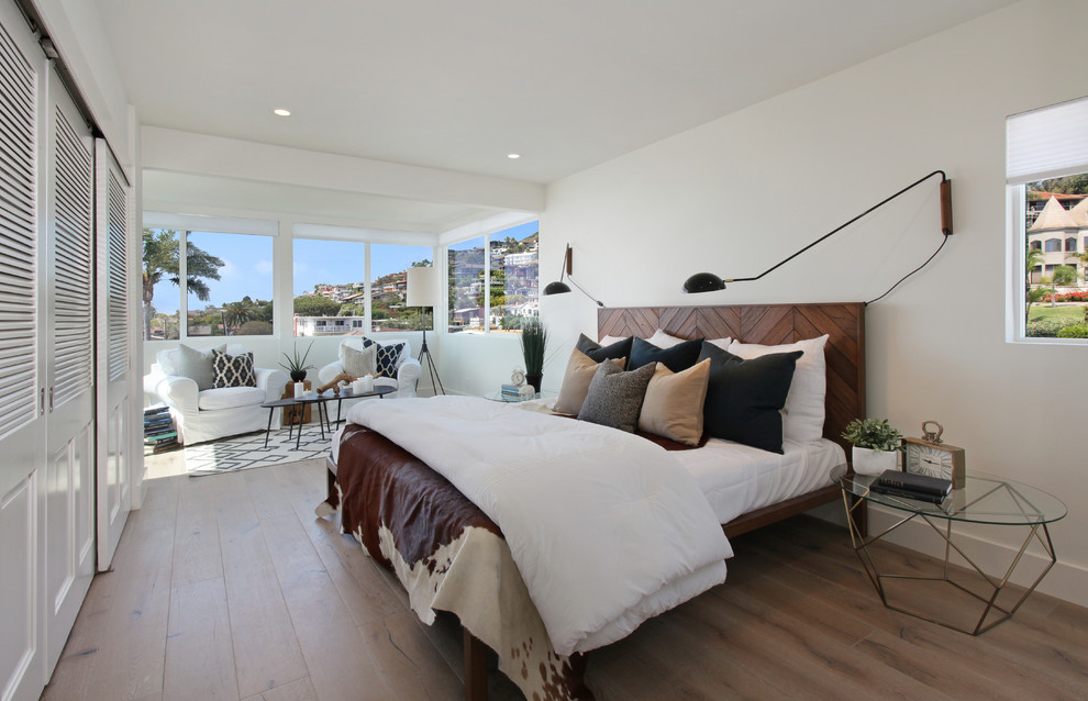 This is an example of a transitional bedroom in Orange County with white walls and dark hardwood floors.