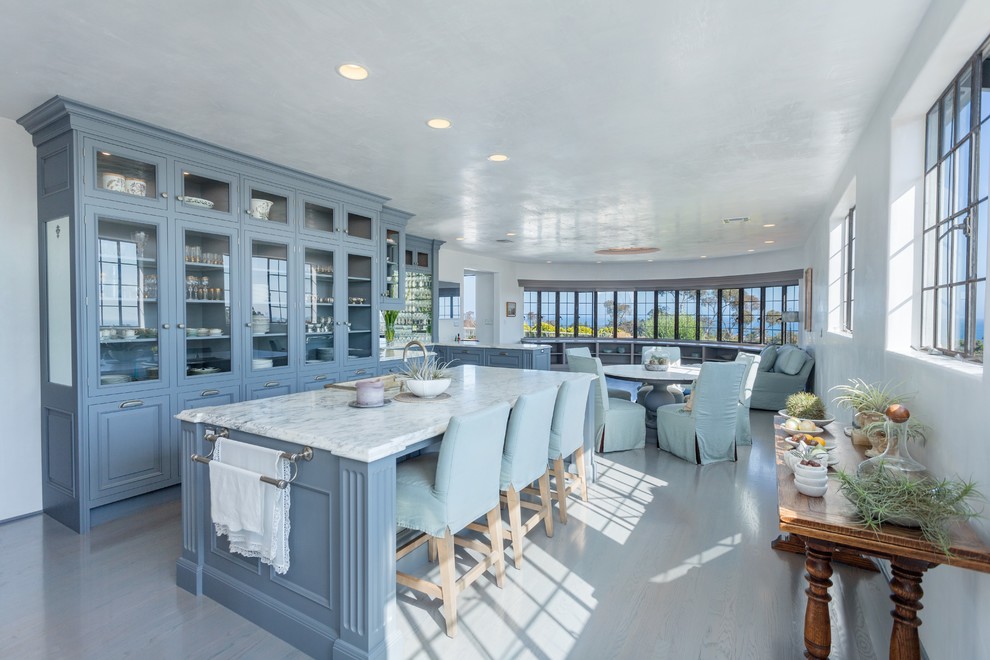 This is an example of a beach style kitchen in Santa Barbara with marble benchtops, a farmhouse sink, raised-panel cabinets and with island.