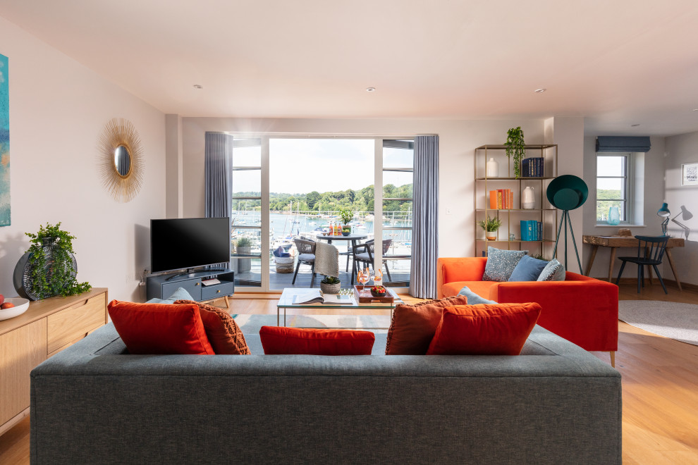 На фото: парадная, открытая гостиная комната среднего размера в морском стиле с белыми стенами, паркетным полом среднего тона, телевизором в углу, оранжевым полом и красивыми шторами без камина с